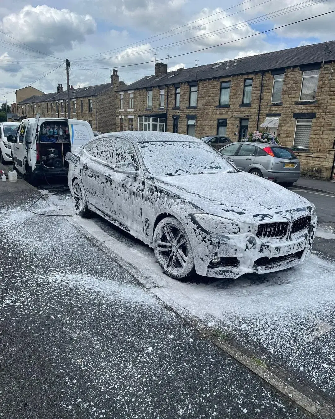 Car covered in snow foam on the street
